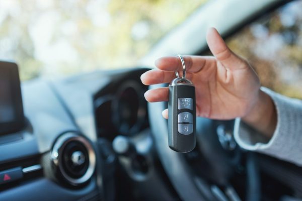 a-woman-holding-and-showing-car-key-while-sitting-in-the-car